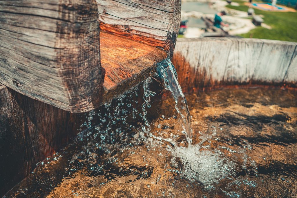 Wasser fließt in Holzfass